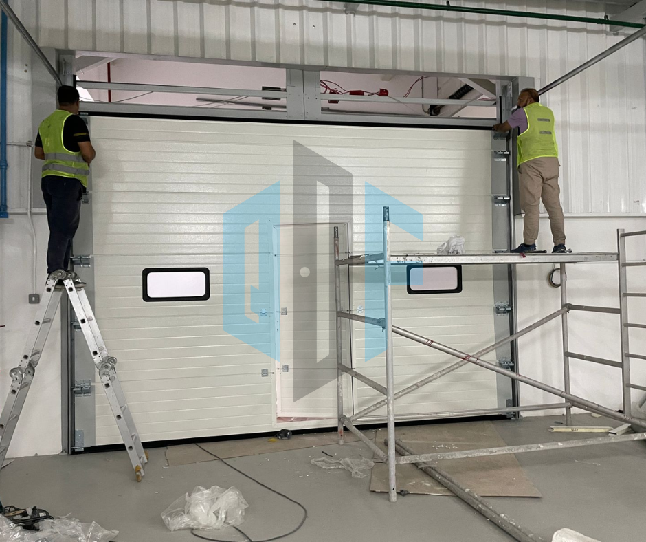 Technicians from Quick Fix Door performing commercial automatic door repair on a large industrial garage door, ensuring smooth operation and security.