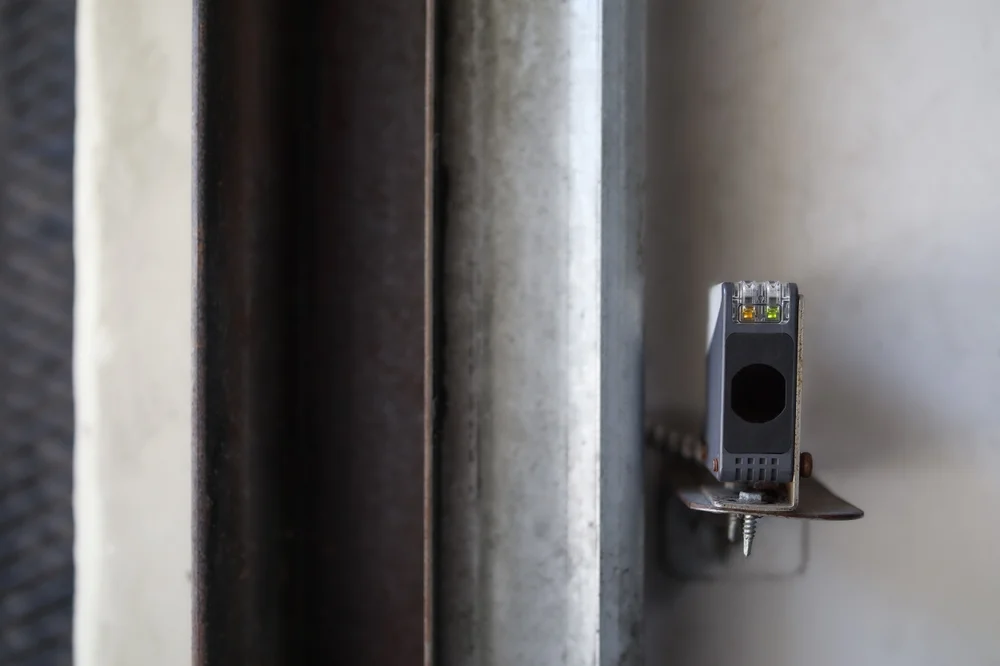 Close-up of aligned garage door safety sensors installed on a Liftmaster garage door system ensuring proper operation and safety.